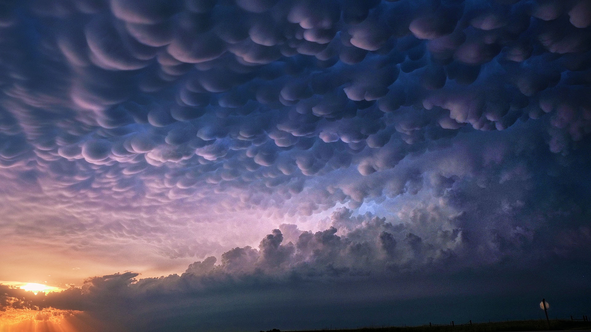 Setting sun and storm cloud layers including mammatus clouds