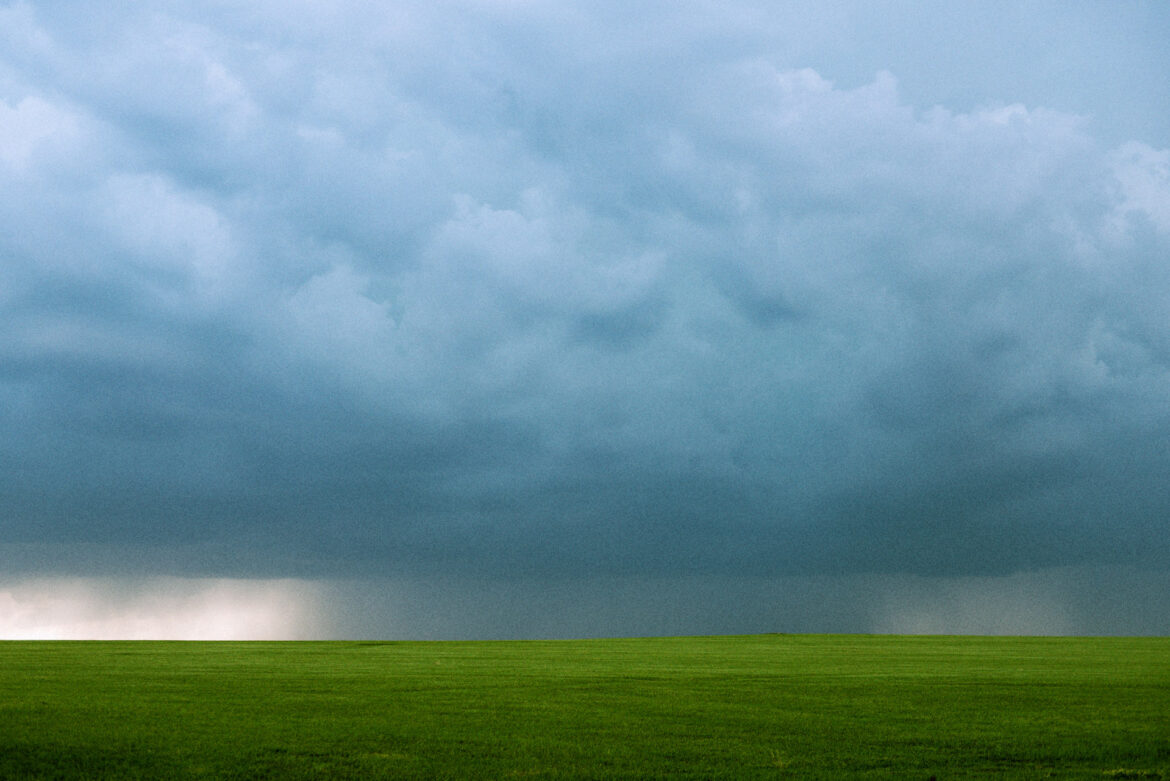 Spring rainstorm over green pasture